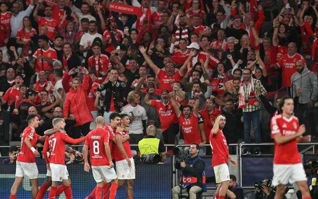 O zagueiro do Benfica, Alexander Bah (C), comemora o terceiro gol do seu time na goleada sobre o Atlético de Madrid