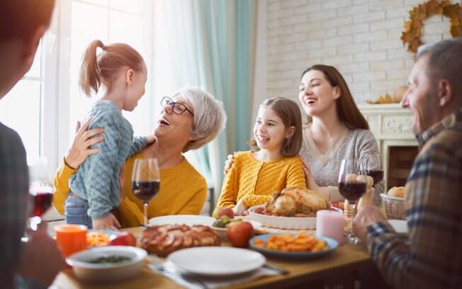 Crianças cumprimentando adultos na mesa de jantar