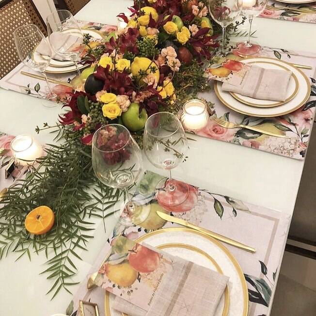 Os jogos americanos e o arranjo central seguiram a temática de flores e frutas mesa posta para Bodas de Casamento