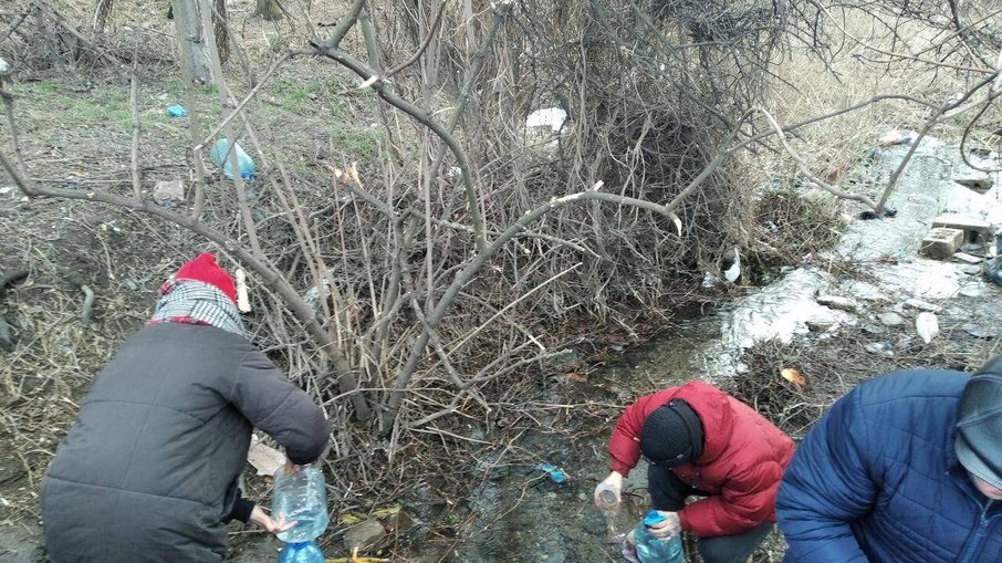 Moradores buscam água em poço em Mariupol