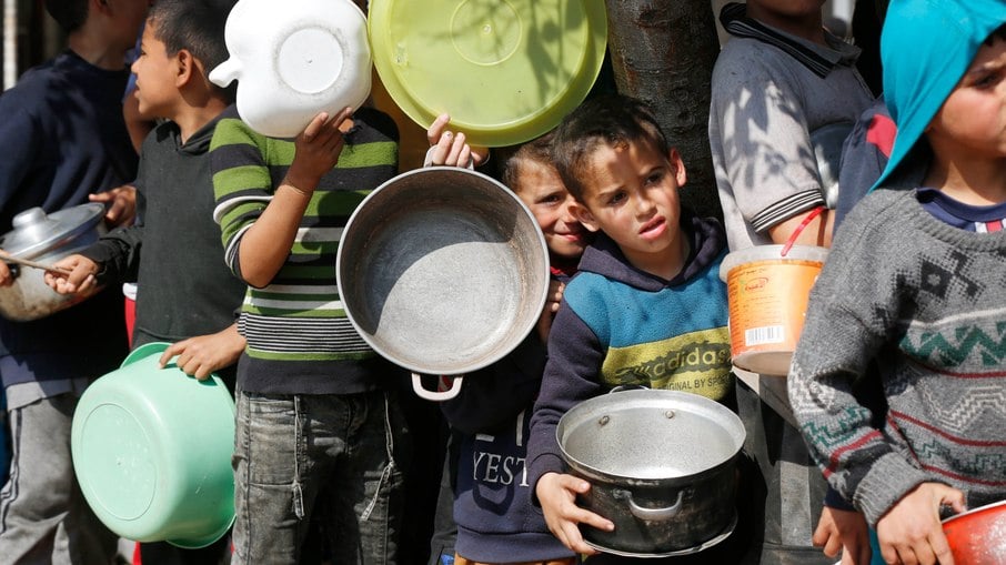 Crianças esperam na fila por comida em Gaza