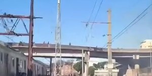 Passageiros caminham pelos trilhos do trem após incêndio no Rio