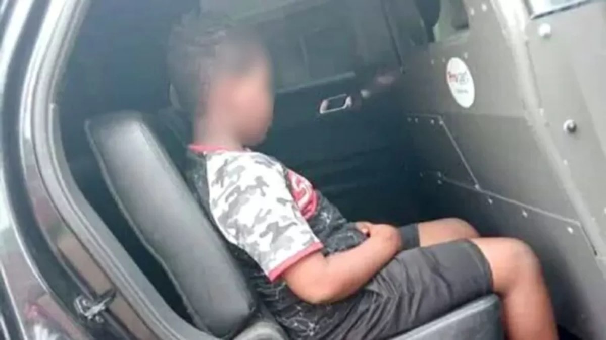 A criança estava fazendo xixi atrás do carro da mãe, quando foi flagrado pela polícia