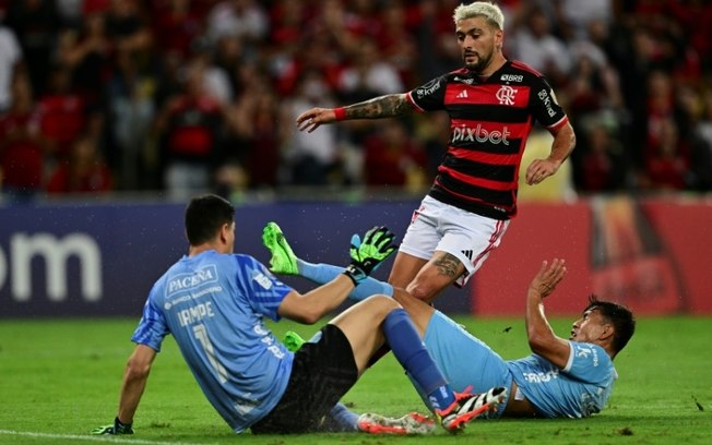 Giorgian de Arrascaeta disputa a bola com Carlos Lampe e José Sagredo durante a vitória do Flamengo sobre o Bolívar na 5ª rodada do Grupo E da Libertadores, no Maracanã