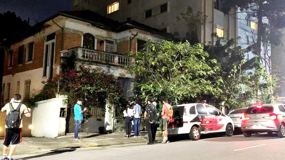 Policiais e curiosos em frente à casa onde Margarida Bonetti morou, em Higienópolis, bairro nobre de SP