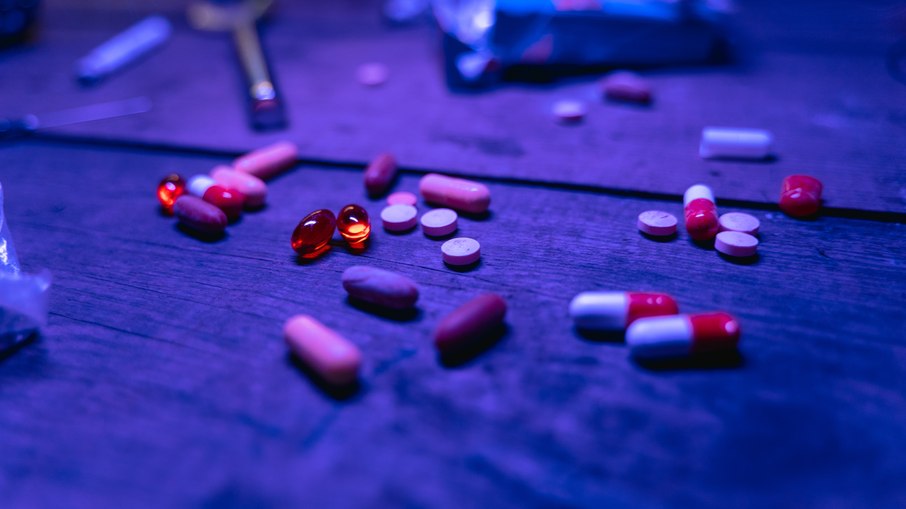 Cachimbo, pílulas e drogas espalhadas pela mesa