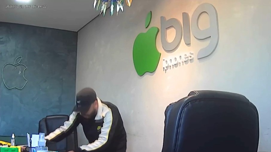 Durante o assalto, o criminoso recolhe diversos celulares expostos para venda, além dos aparelhos pessoais das vítimas