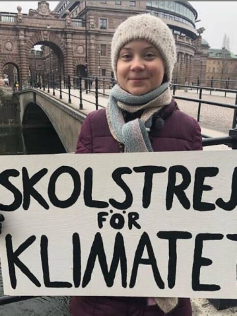Greta Thunberg segurando cartaz em protesto