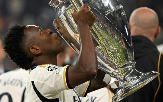 O atacante brasileiro Vinícius Júnior beija o troféu da Liga dos Campeões, conquistado pelo Real Madrid após derrotar o Borussia Dortmund na final, no estádio de Wembley, em Londres, no dia 1º de junho de 2024.