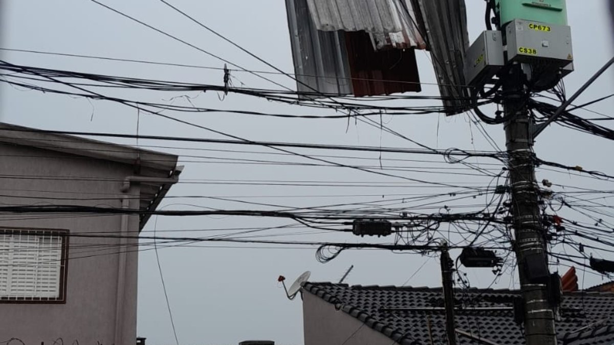 Telha de zinco foi parar na rede elétrica após o temporal. Telha de zinco foi parar na rede elétrica após o temporal.