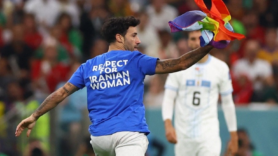 O homem invadiu o campo com a bandeira LGBTQIA+ durante a partida entre Portugal e Uruguai nesta segunda-feira (28).
