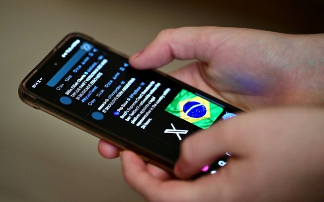 Um usuário brasileiro da rede social X, o antigo Twitter, navega por postagens em um celular em Brasília, em 31 de agosto de 2024