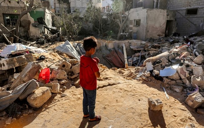 Menino entre os escombros de edifício em Rafah, no sul da Faixa de Gaza, em 8 de maio de 2024