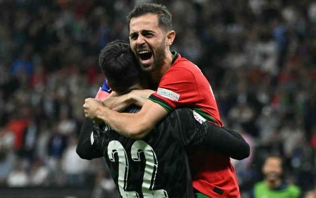 O goleiro português Diogo Costa (à esquerda) defendeu três pênaltis na vitória sobre a Eslovênia