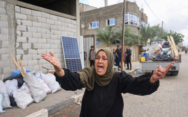 Mulher reclama enquanto deslocados palestinos recolhem seus pertences para deixar Rafah, no sul da Faixa de Gaza, em 6 de maio de 2024