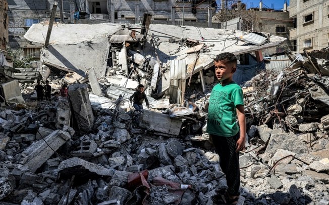 Um menino olha as ruínas de um prédio destruído em 9 de abril de 2024 em Rafah, Faixa de Gaza