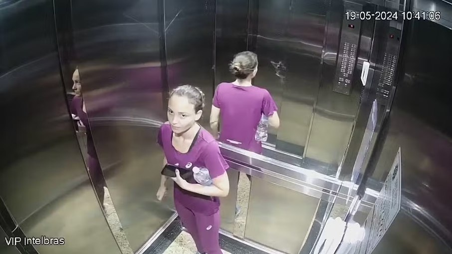 Júlia Andrade com roupas de academia no interior do elevador