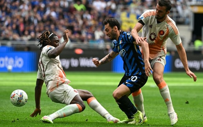 O meio-campista da Inter de Milão, Hakan Calhanoglu, disputa a bola com os meias da Roma, Manu Koné e Bryan Cristante, durante a 34ª rodada da Serie A, em 27 de abril de 2025, em Milão. O meio-campista da Inter de Milão, Hakan Calhanoglu, disputa a bola com os meias da Roma, Manu Koné e Bryan Cristante, durante a 34ª rodada da Serie A, em 27 de abril de 2025, em Milão.