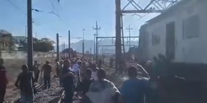Passageiros caminham pelos trilhos do trem após incêndio no Rio