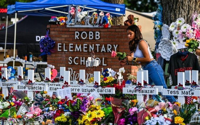 (Arquivo) Jovem deposita flores em monumento improvisado na Escola Primária Robb, em Uvalde, Texas, em 28 de maio de 2022 (Arquivo) Jovem deposita flores em monumento improvisado na Escola Primária Robb, em Uvalde, Texas, em 28 de maio de 2022