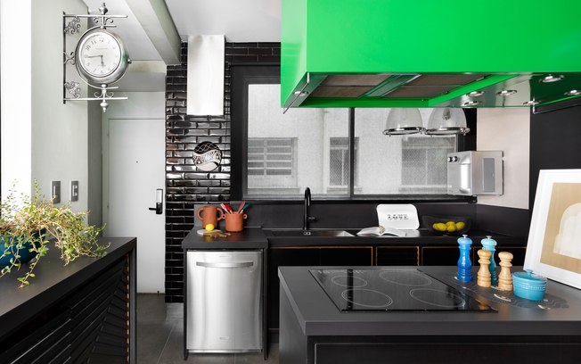 Cozinha com coifa verde e lavabo preto e branco destacam-se em apê