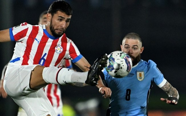 O zagueiro paraguaio Junior Alonso (E) e o meia uruguaio Nahitan Nandez disputam a bola durante a partida entre Uruguai e Paraguai, pelas eliminatórias sul-americanas no estádio Centenário, em Montevidéu, em 6 de setembro de 2024.