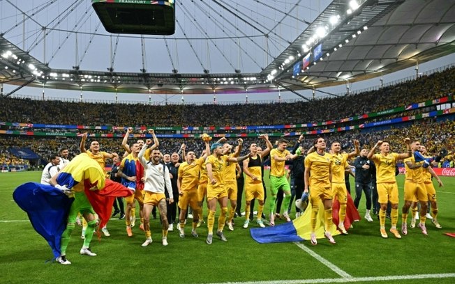 Jogadores e comissão técnica da Romênia comemoram a classificação para as oitavas de final da Euro após o empate em 1 a 1 com a Eslováquia nesta quarta-feira