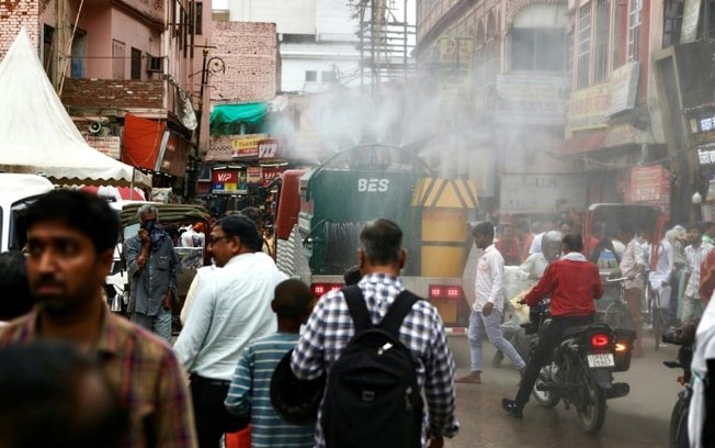 Transeuntes sob forte calor em uma rua de Uttar Pradesh, o país mais populoso do mundo, em Varanasi, Índia, 24 de junho de 2024