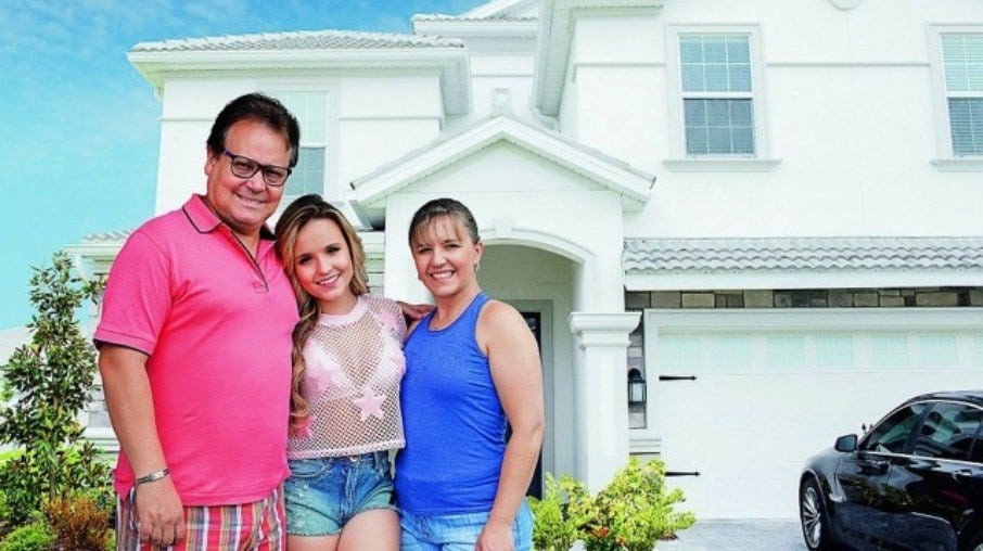Larissa Manoela com os pais em frente a mansão