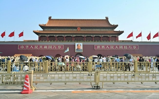 Pedestres passam em frente ao retrato do falecido líder comunista Mao Tsé-tung na entrada da Cidade Proibida, na Praça da Paz Celestial, em Pequim, em 4 de junho de 2024