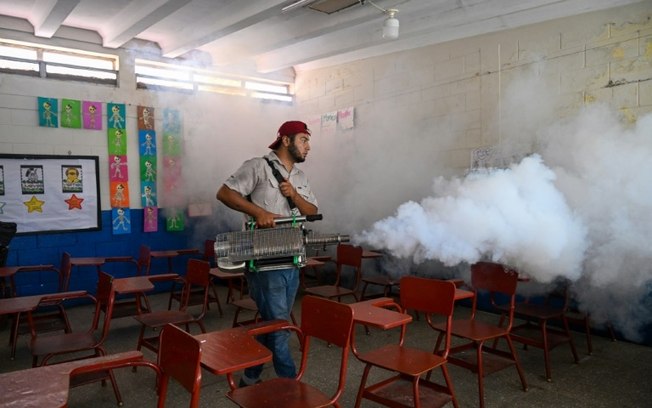 Um trabalhador do Ministério da Saúde pulveriza inseticidas contra o mosquito Aedes aegypti dentro de uma escola na Cidade da Guatemala, em 24 de maio de 2024