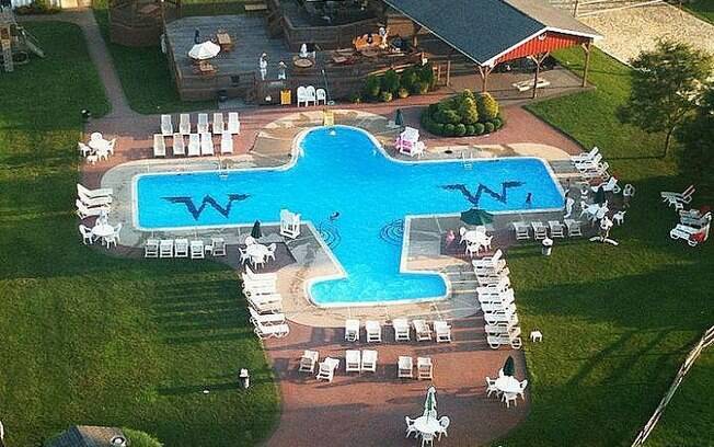 A piscina em formato de avião está localizada próxima a uma pista de pouso e faz parte da lista de fotos de piscinas