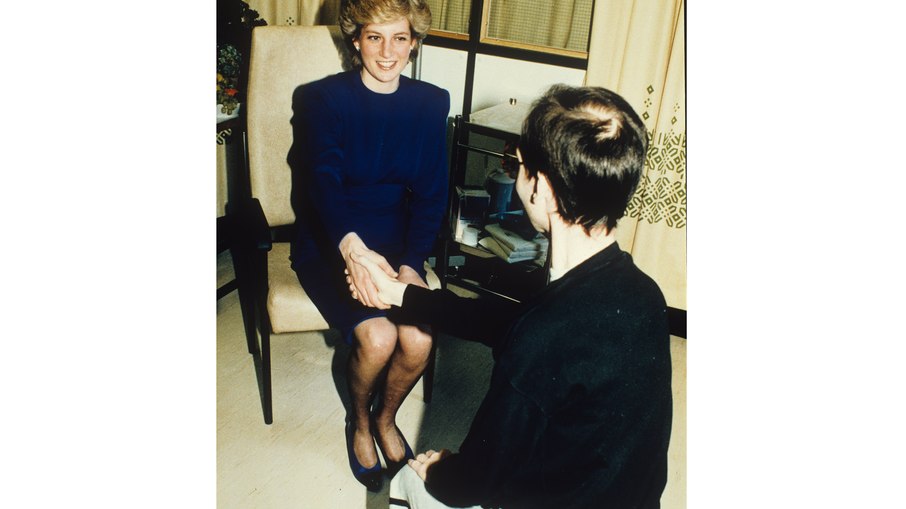 Esta imagem mostra Diana, a Princesa de Gales, apertando a mão de um paciente sem luvas em abril de 1987. O ato histórico ocorreu no Middlesex Hospital, em Londres, durante a inauguração da ala Broderip