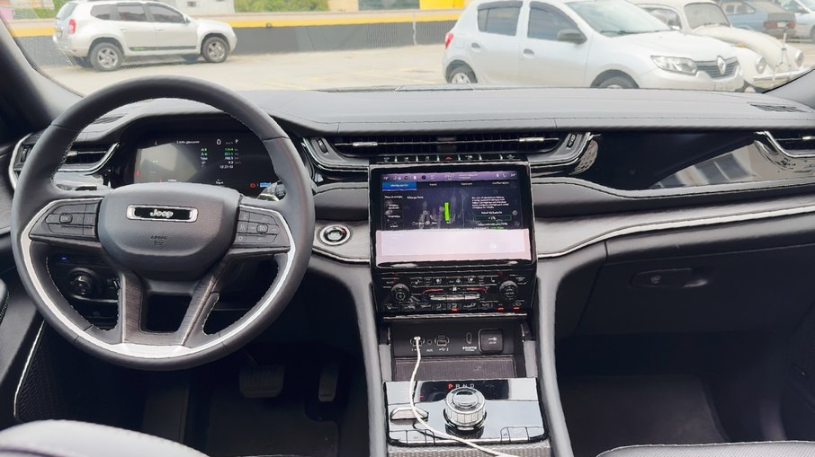 Interior do Grand Cherokee 4xe traz ótimos acabamentos e tela até para o passageiro Interior do Grand Cherokee 4xe traz ótimos acabamentos e tela até para o passageiro