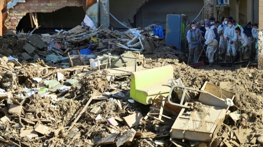 Um grupo de voluntários limpa uma rua devastada pelas enchentes na cidade espanhola de Paiporta, na província de Valência, em 10 de novembro de 2024