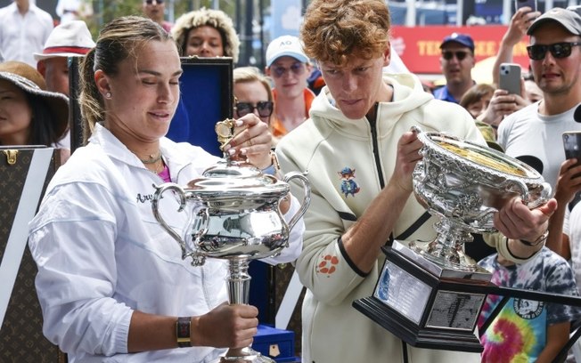 Os últimos campeõs do Aberto da Austrália, a bielorrussa Aryna Sabalenkae o italiano Jannik Sinner, posam com os troféus nesta quinta-feira, em Melbourne