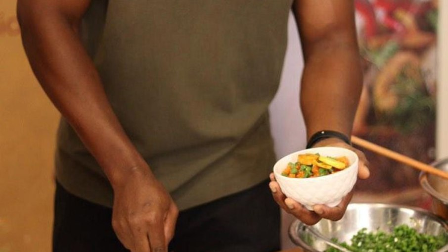 Chef nigeriano Evergreen Okolo prepara o arroz jollof para os cerca de 20 convidados do projeto Sabores e Lembranças