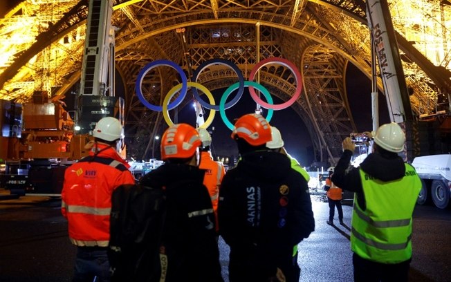 Operários retiram os anéis olímpicos da Torre Eiffel