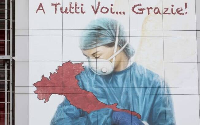 Um mural dedicado a todos os trabalhadores da saúde italianos, representando uma enfermeira embalando a Itália e lendo 'A todos vocês ... obrigado!'