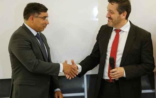O ministro de Petróleo da Venezuela, Pedro Tellechea, cumprimenta o representante da Repsol, Luis García, após a assinatura de um acordo petrolífero, em Caracas, em 17 de abril de 2024