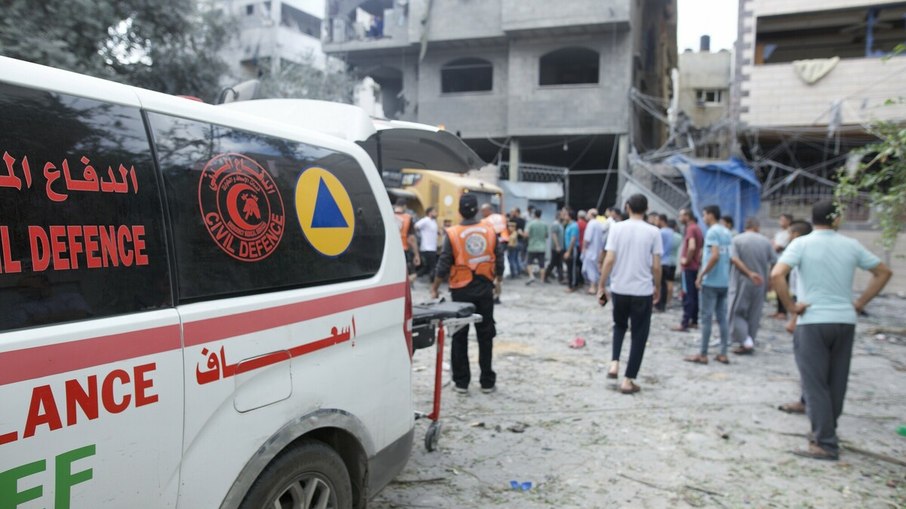 Bombeiros, juntamente com o pessoal da defesa civil, médicos na cidade de Gaza e outros membros da comunidade, unem forças para limpar os escombros de uma casa atingida pelas forças israelitas na área de Al Remal