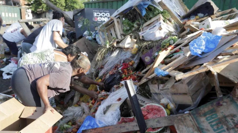 Pessoas vasculham caixas e material jogado fora por comerciantes da Ceasa, no Rio de Janeiro