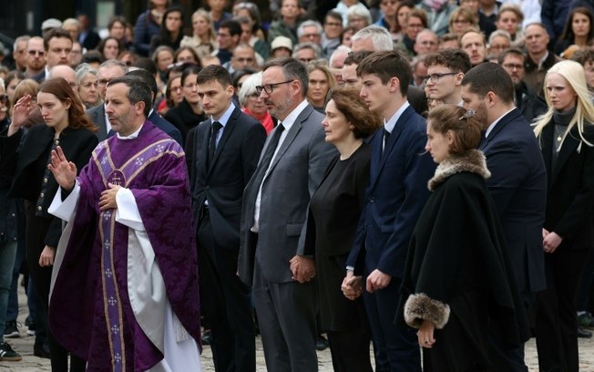 Um padre gesticula perto de familiares de Philippine, antes de sua cerimônia fúnebre do lado de fora da catedral de Versalhes, perto de Paris, em 27 de setembro de 2024