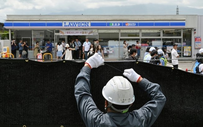 Trabalhador instala barreira para bloquear a vista do Monte Fuji, na cidade de Fujikawaguchiko, município de Yamanashi