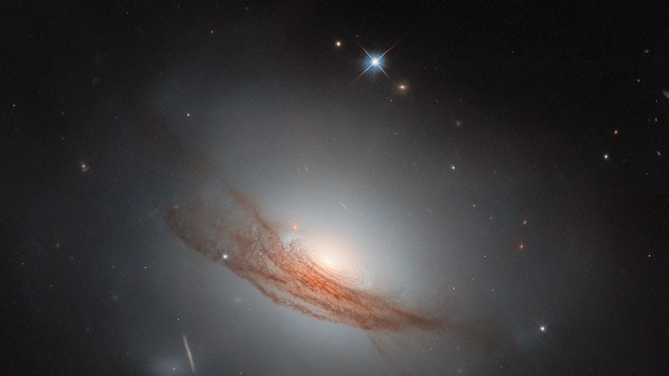 Hubble revela galáxia com anéis escuros e passado
violento