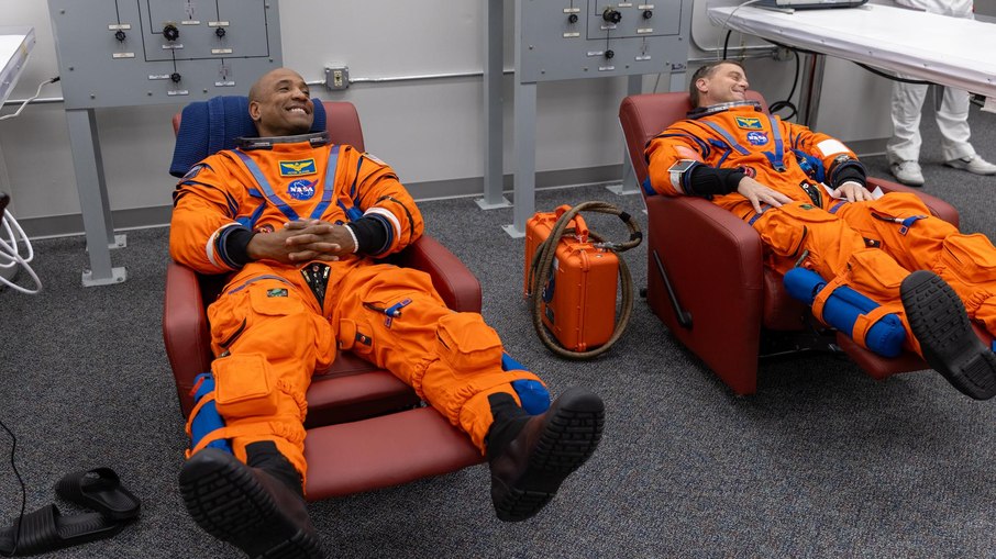 Os astronautas Victor Glover e Reid Wiseman fazem checagem do traje espacial no Kennedy Space Center, durante simulação do dia do lançamento da Artemis II.