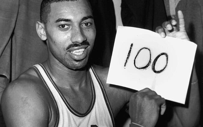 Wilt Chamberlain segura placa feita a mão após marcar incríveis 100 pontos em um só jogo