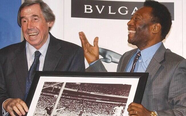 Gordon Banks durante encontro com Pelé, ambos segurando um quadro com a 