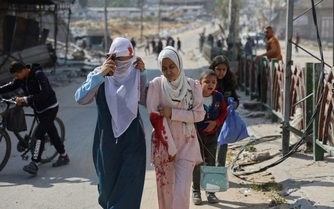 Família acompanha menina palestina ferida após bombardeio israelense na área do mercado de Firas, na cidade de Gaza