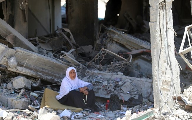 Uma mulher palestina senta-se em meio aos escombros no campo de Jabalia, no norte da Faixa de Gaza, em 31 de maio de 2024